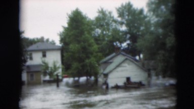 1951: multiple houses and yards flooded by fast moving river of water WILLMAR