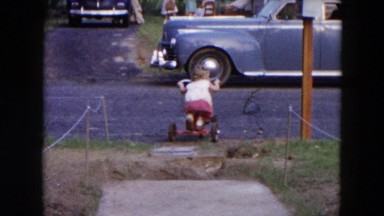 1954: little girl rides a tricycle down the street HICKSVILLE, NEW YORK