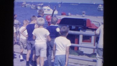 1954: young boys observe a large docked boat in the wate NEW YORK