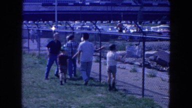 1954: children walking along side a chainlink fence NEW YORK