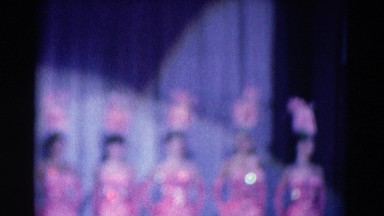 1969: a chorus of beautiful showgirls on stage in elaborate pink costumes