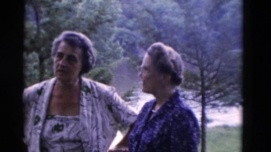 1949: four senior citizens enjoying conversation and cocktails by the lake