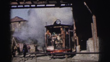 1962: men riding a small train with someone watching them pass BANGKOK, THAILAND