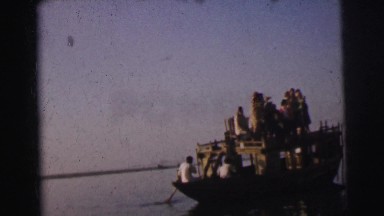 1962: a group of people on a large boat as they pass by people working