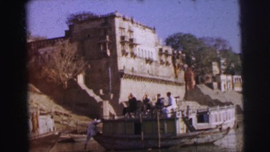1962: people are seen rowing a boat beside a high clock tower BANGKOK, THAILAND