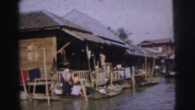1962: asian fishing community built on the water with many buildings