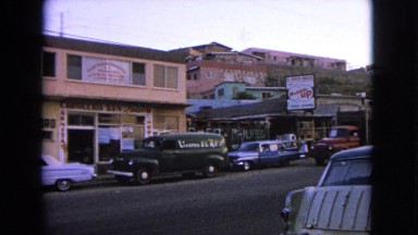 1963: a city road on day time with parked vehicles and busy environment