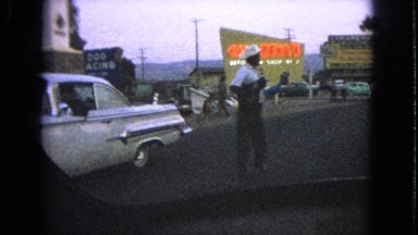 1963: man in white hat looks around as white car drives off BARRINGTON, ILLINOIS