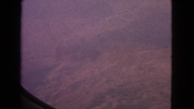 1963: airplane window view of patchwork countryside and mountain ranges