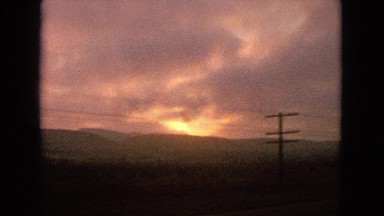 1963: the video shows an outdoor with of a view beside a highway and sun is seen