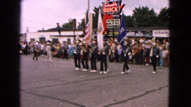 1963: a band playing musical instruments as they march in rhythm