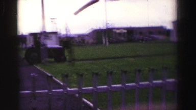 1952: Tractor Pulls Tarp-Covered Vehicle in Rural England