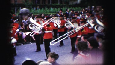 1952: People Watching a Parade Progress by with Marching Band and Horse-Drawn Carriage in England