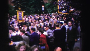 1952: the scene shows people overlooking a parade in the go and seem very happy