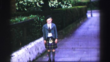 1952: a kid with uniform is seen trying hard to open his eyes ENGLAND
