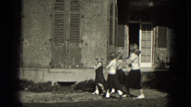 1953: Four young girls in short sleeve shirts and long skirts doing a rhythmic dance routine