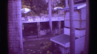 1971: Beach chairs people relaxing outdoors lounges tables under striped