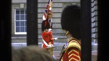 1969: a crowd watching uniformed guards lined up beyond a fence IRELAND
