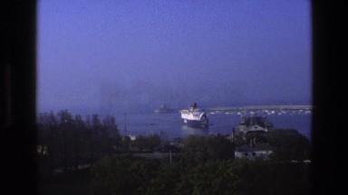 1969: A Large Ship Slowly Pulling Into a Beautiful Irish Harbor with a Pier