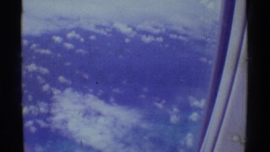 The View of a Wing and Clouds in a Blue Sky from an Airplane Window