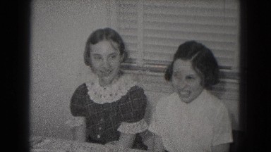 1953: pretty young girls sitting around a table are talking and smiling