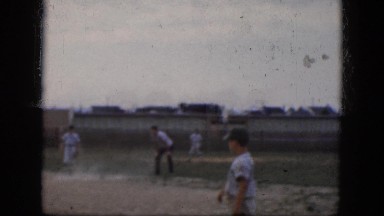 1964: handsome young boys in uniforms playing a game of baseball on the field