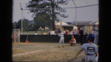 1964: a young boy on a baseball team is up at the plate swinging. ALBANY