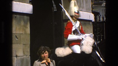 1969: A Man Colorfully Clad Pulls on the Reins of His Black Horse
