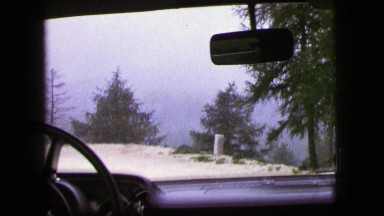 1963: A Rustic Winding Road and Mountains Seen from a Moving Vehicle in Germany