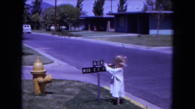 1970: Small Female Child Making Slow Spins Around Fire Hydrant in White Sands, Florida
