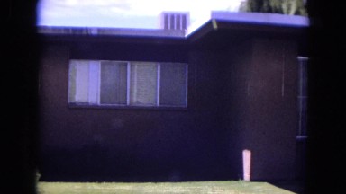 1970: young man mowing his lawn while everything is fine in the neighborhood