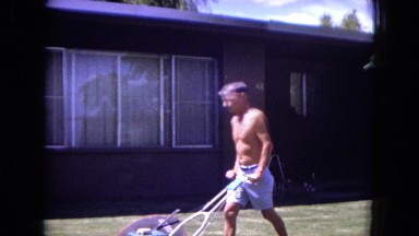 1970: Man Roaming Front of Home and Girl Baby Playing Near