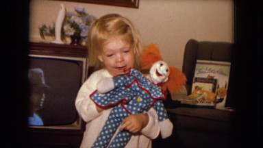 1970: Child with Doll Outdoors in White Sands, Florida
