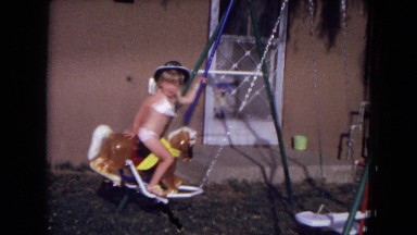 1973: Young Child Riding Horse on Swingset New Mexico