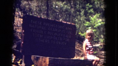 1973: Child Sitting Beside Sign Board at New Mexico Zoo