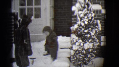 1944: a small boy walking down snow covered steps before rising and walking