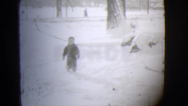 1944: a small boy cursing up a snow covered hill towards his little sled