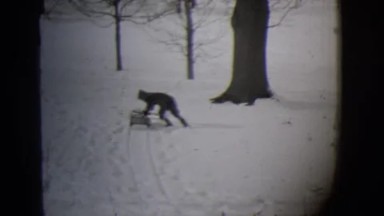 1944: Child Playing on Sled Racing Down Snow-Covered Hill in Michigan