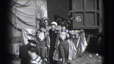 1948: women in costumes featuring capes posing with a handsome young sailor