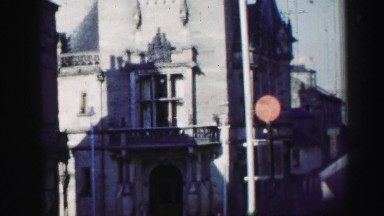 1952: a town with an antique building holding a clock in a tower EDINBOURGH,