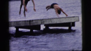1961: two young men in shorts diving off a dock into the water below CAMDEN, NEW