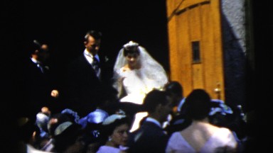 1961: husband and wife walking into a crowd with their best man and maid