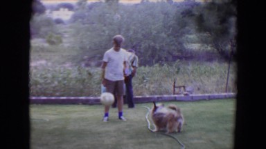 1961: boy playing soccer with his dog outside in the backyard TOLEDO, OHIO