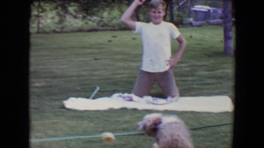 1961: a kid is seen posing while a dog plays with a ball TOLEDO, OHIO