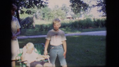1968: a family with two boys and a cute little dog preparing to sit in lawn
