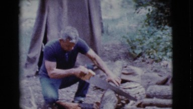 1968: a man cutting wood to prepare food COTTONWOOD, ARIZONA