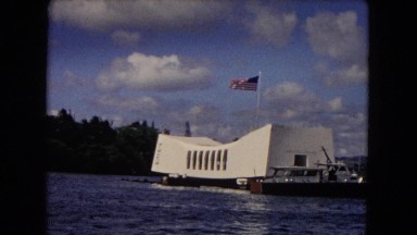 1968: dark, rippling waves, front a bayside area, with boats and small houses,