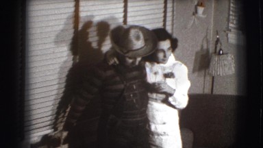 1941: a male and female individual, stand before a window, covered with slats