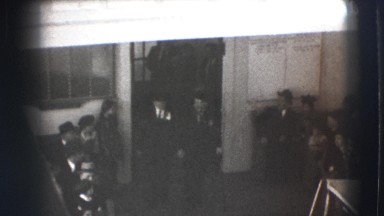 1941: overhead view of two mean exiting a building and walking through crowd NY
