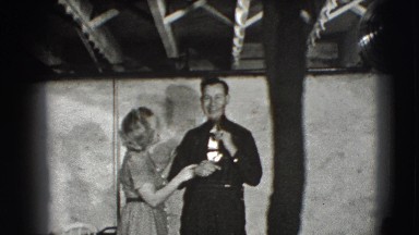 1941: black and white film of a man and a woman and the man is fixing his tie